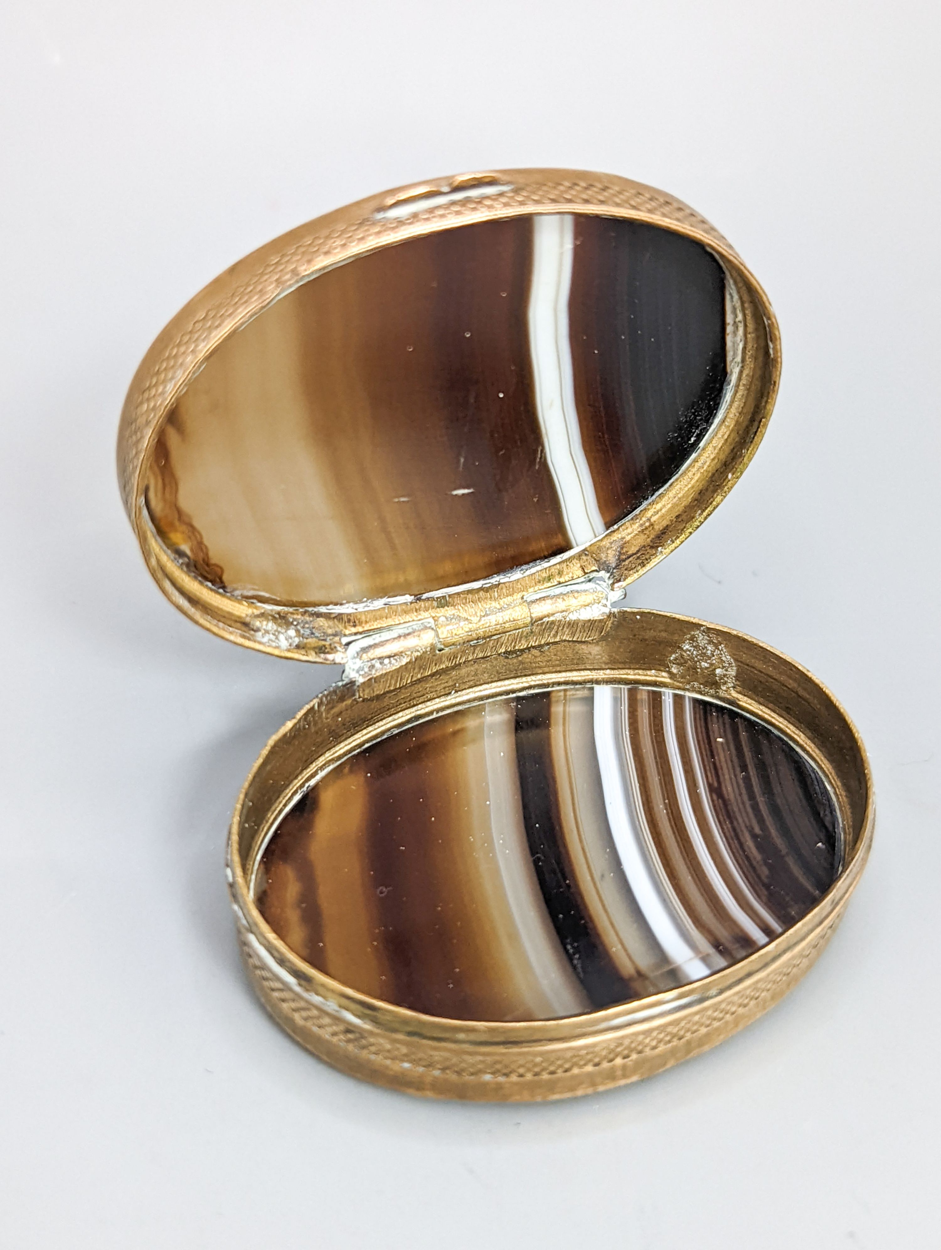 A 19th century lignum vitae pestle and mortar, 10.5cm, a pair of treen butter spoons and an agate mounted brass pillbox